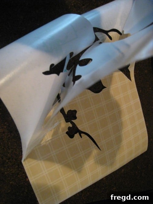 Silhouette machine precisely cutting a bird-themed stencil design onto a sheet of contact paper