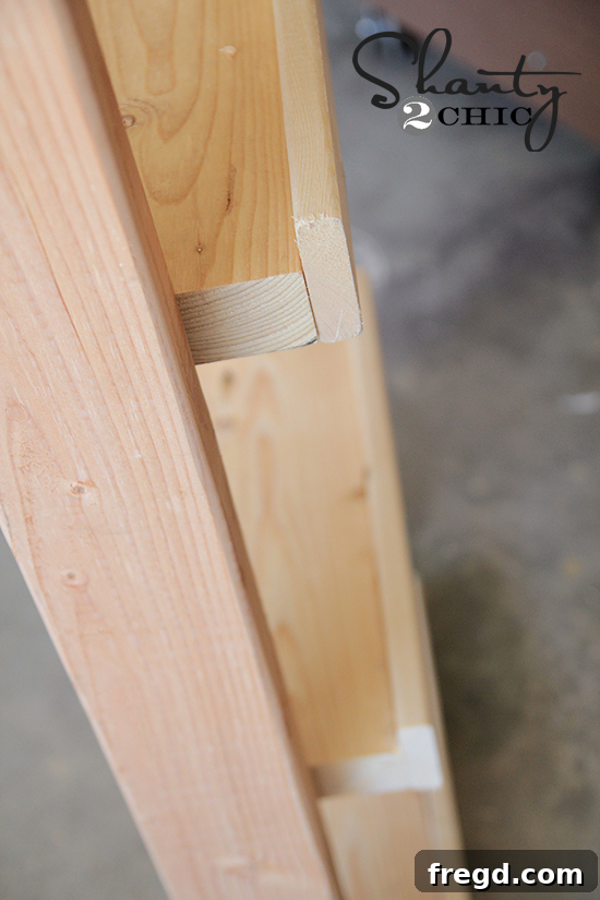 DIY One Hour Wood Wall Planter 7 A 1x3 pine trim piece being glued and nailed to the front edge of a 2x6 shelf, showcasing the addition of decorative trim.