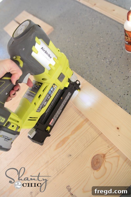 Securing side frame to wood sign with Ryobi AirStrike Brad Nailer