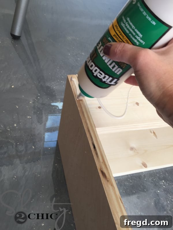 Applying wood glue to attach the face frame to the cabinet