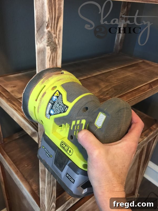 Distressing stained office tower with orbital sander