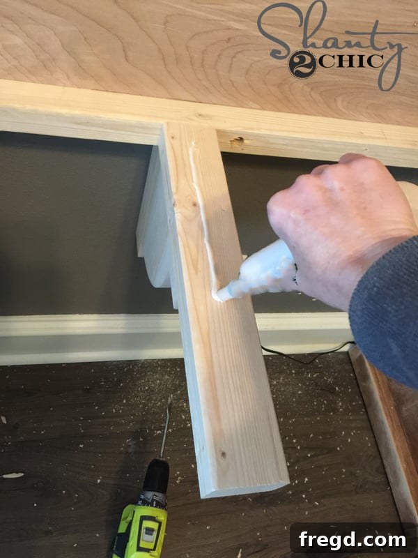 Applying wood glue to the top of the desk cleat