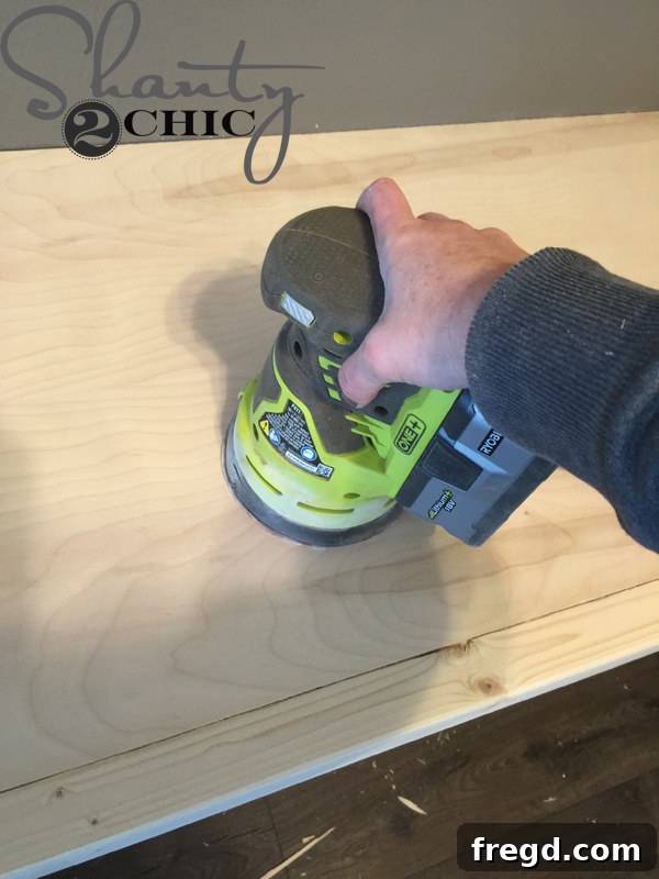Sanding the floating desk top with an orbital sander