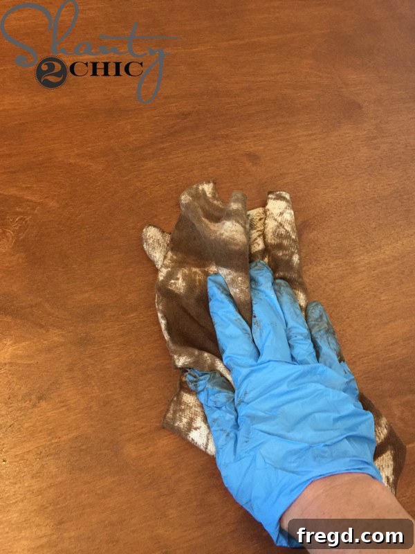 Wiping excess wood stain with a clean cloth