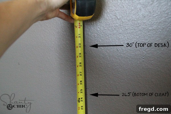 Marking the wall to indicate the desired desk height and cleat position