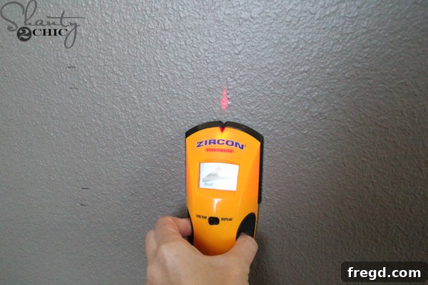 Using a stud finder to locate wall studs for secure desk mounting