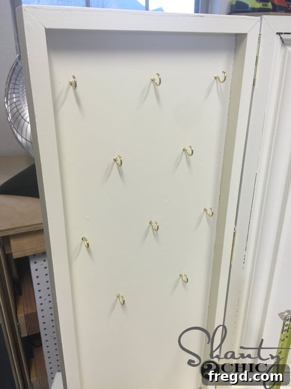 Alternating eye hooks inside vanity doors for jewelry
