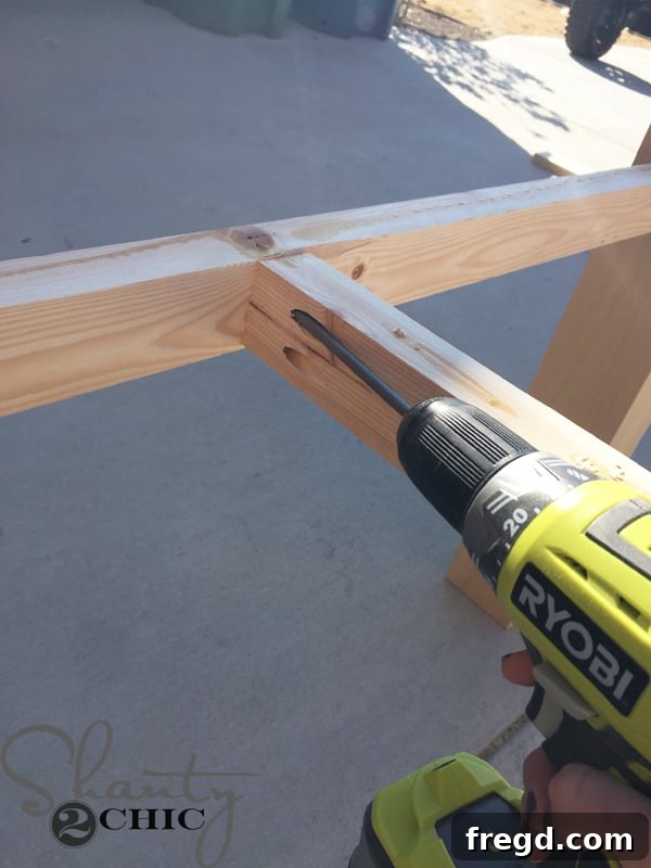DIY Modern Open Concept Farmhouse Table HGTV Style 10 Attaching cross supports to the apron of the table frame