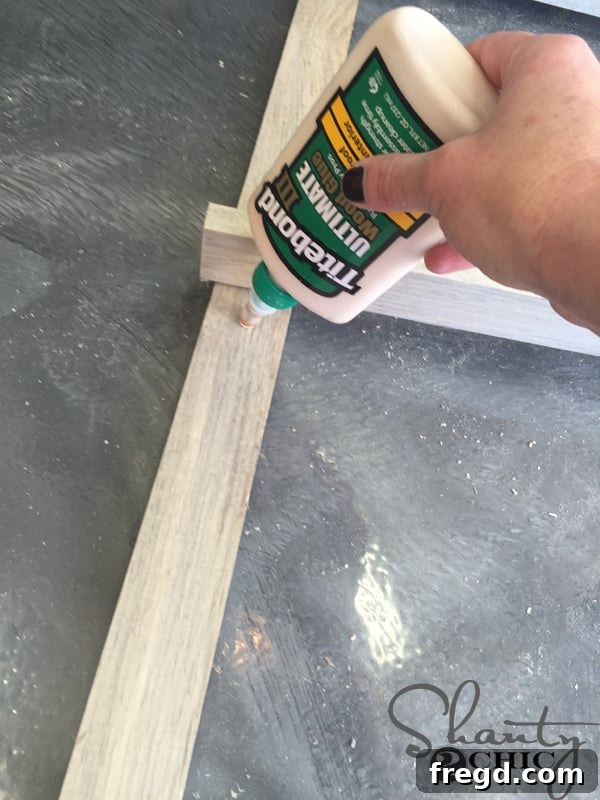 Close-up of wood glue being applied to the end of a ladder rung
