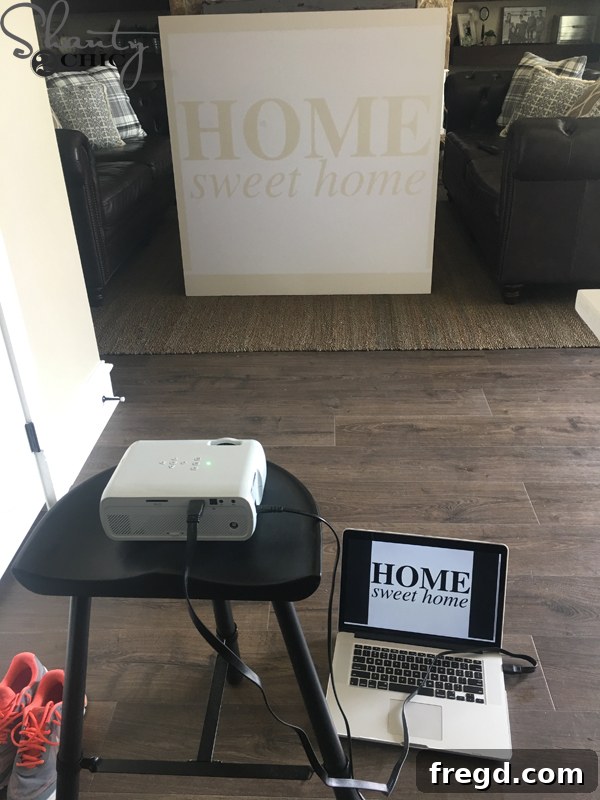 Projector displaying 'Home Sweet Home' design on painted plywood.