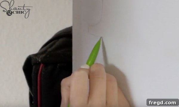 Tracing letters onto the sign with a pencil.