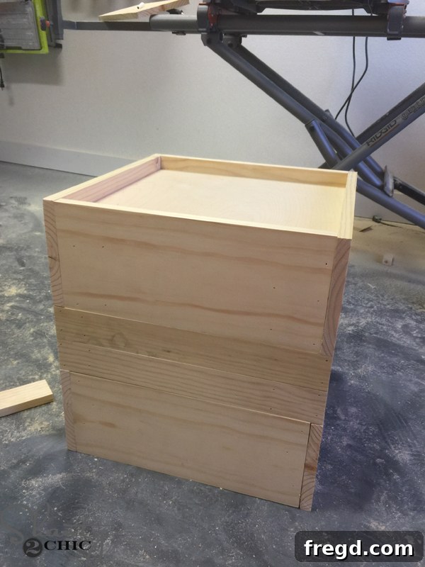 Build Your Own Rolling Storage Ottoman Coffee Table 14 Longer wooden planks being attached to the third side of the ottoman, ensuring they are flush with previously installed planks for a seamless look.