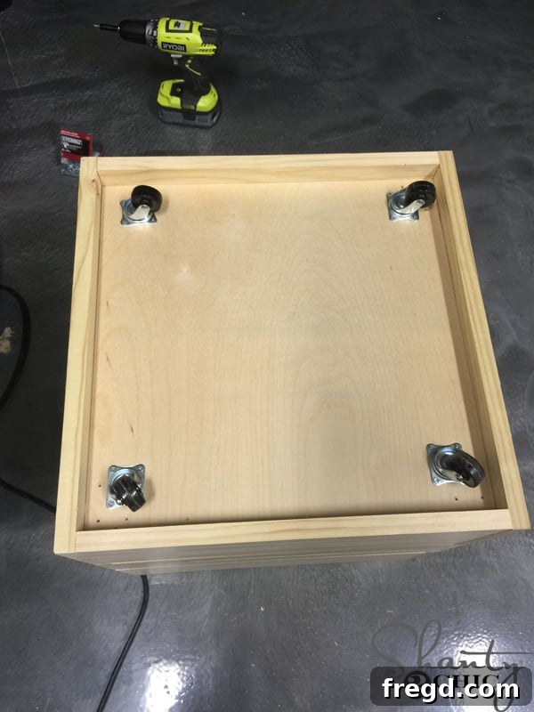 Build Your Own Rolling Storage Ottoman Coffee Table 15 An ottoman unit, with all its side panels completely attached, shown upside down in a workshop setting.