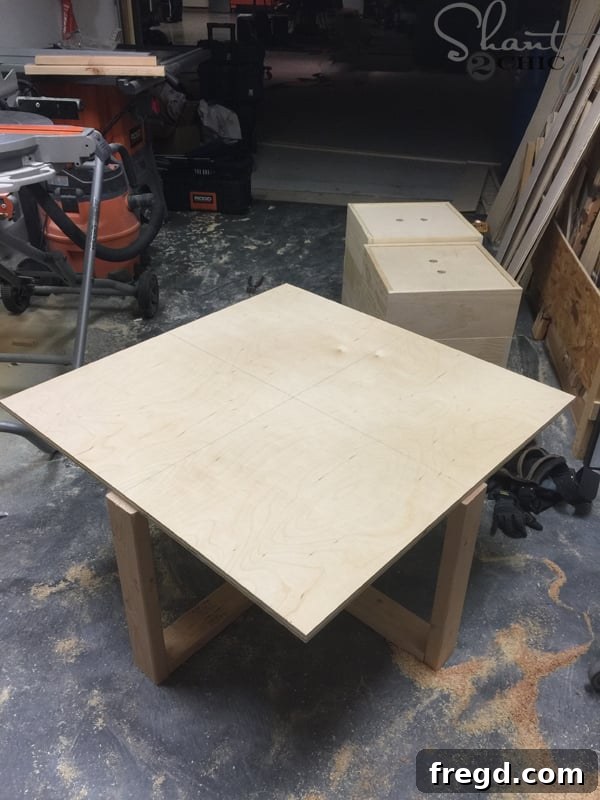 Build Your Own Rolling Storage Ottoman Coffee Table 23 A wooden tabletop with faint pencil lines drawn down its center, indicating preparation for a decorative pattern layout.