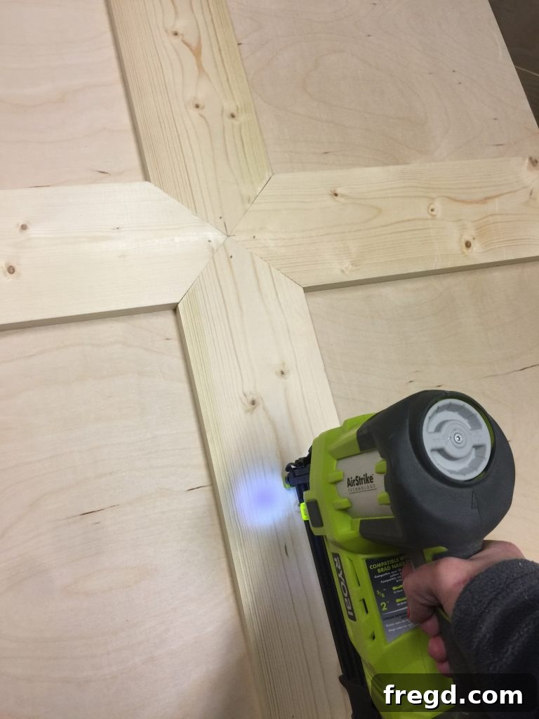 Build Your Own Rolling Storage Ottoman Coffee Table 27 A worker carefully aligning and attaching wooden planks with angled ends to a tabletop, forming a herringbone pattern, using glue and nails.
