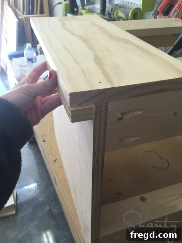 Build Your Own Rolling Storage Ottoman Coffee Table 9 An ottoman bottom being attached to the 'L' supports using pocket screws and wood glue, forming the robust base of the storage unit.