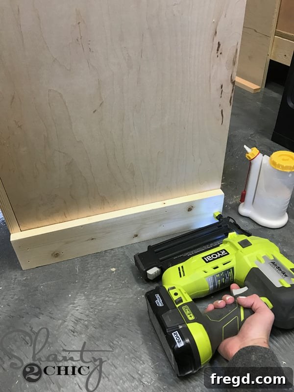 Craft Your Own Sliding Barn Door Nightstand 18 Attaching the side base trim to the nightstand, showcasing precise fit