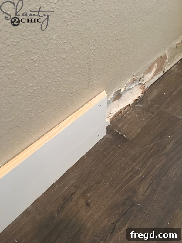 Ultimate Laundry Room Makeover 5 Applying construction adhesive to 1x6 primed MDF board
