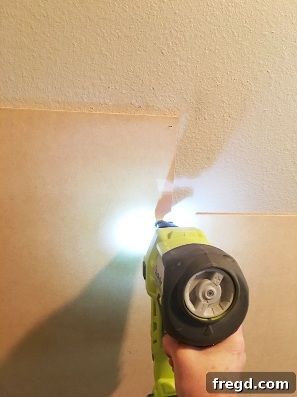 Ultimate Laundry Room Makeover 8 Applying construction adhesive to the back of an MDF panel