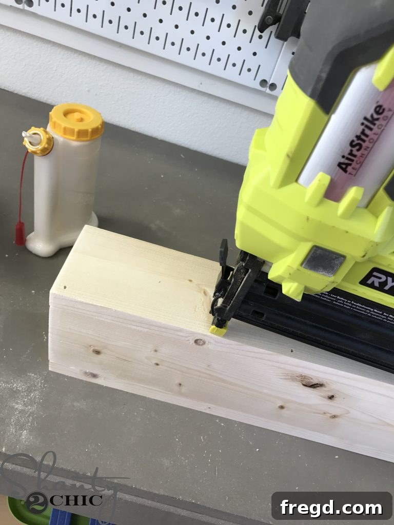Using a Ryobi 18-Volt Airstrike Nailer to attach 1x2 pieces to a 1x4 board with precision, forming the arm guide for the lounge chair.