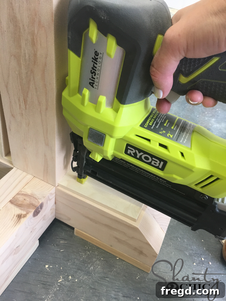Attaching the Craft Board Trim to the table base with brad nails for a clean finish.
