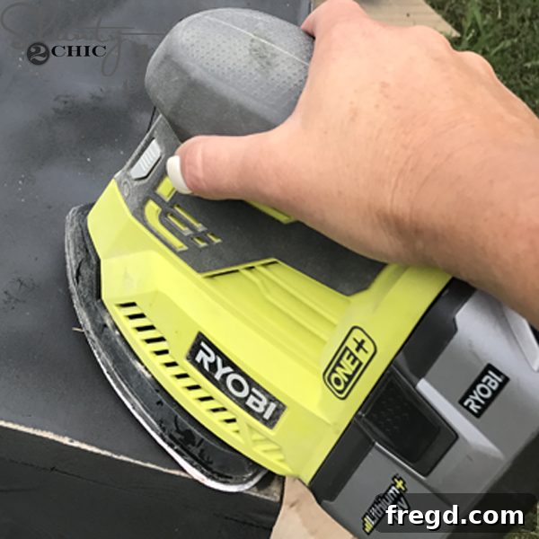 Distressing the edges of a rustic blanket ladder with a sander