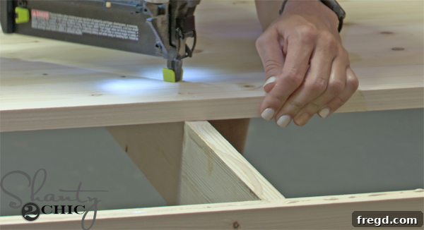 Attaching tabletop planks to the coffee table frame, securing ends to aprons