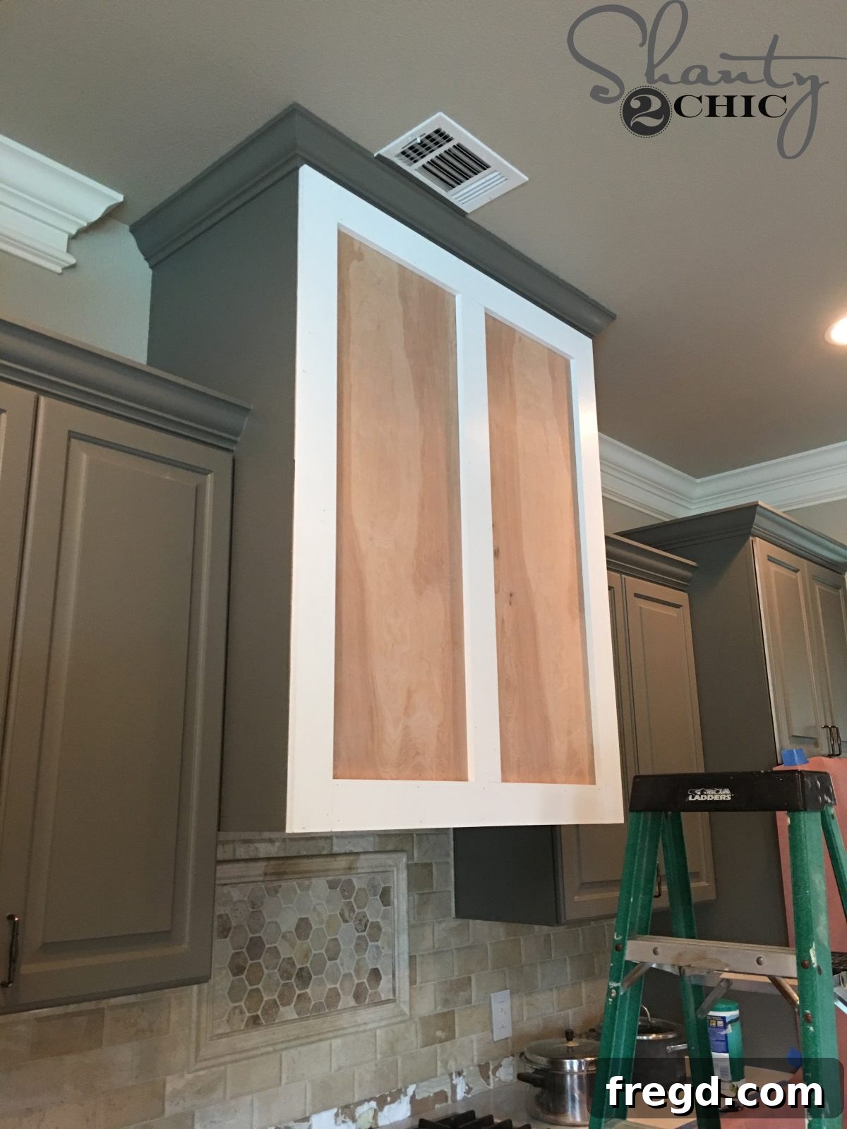 Craft Your Own Barn Door Range Hood 9 Installing the top and bottom horizontal trim pieces to complete the outer frame of the barn door vent hood.