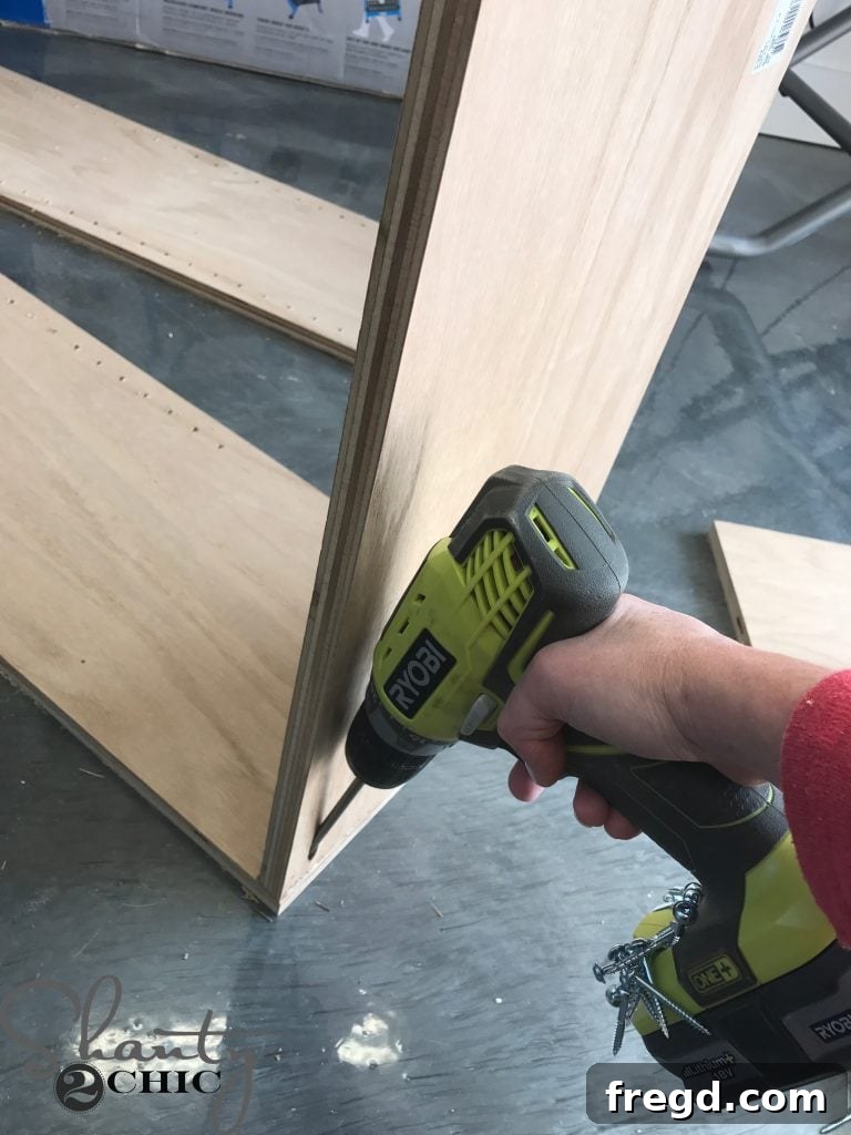 Applying wood glue to cabinet panel edges for assembly