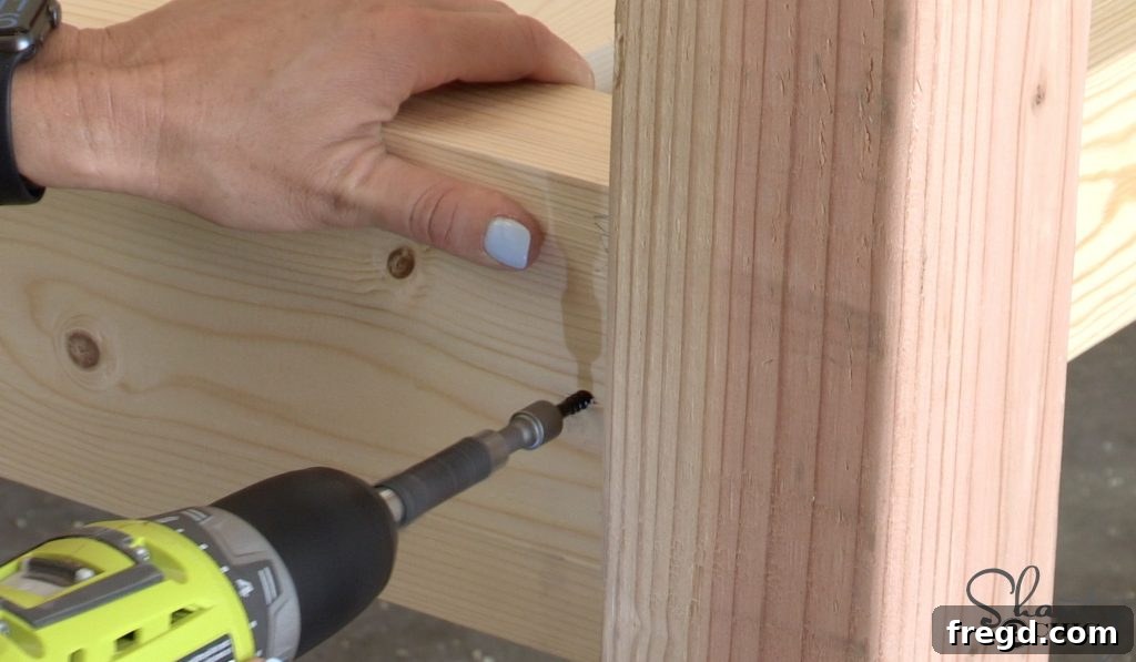 Attaching back slats to the day bed posts with metal angles and using a spacer for even distribution