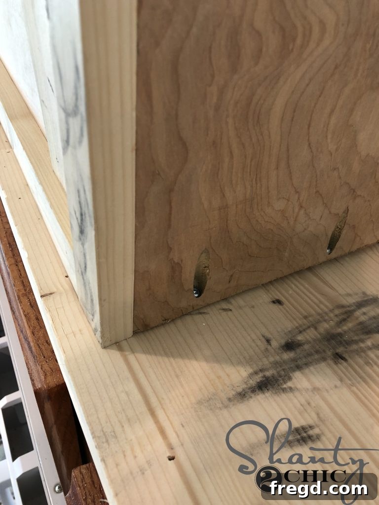 Positioning and securing the completed hood cabinet in the kitchen