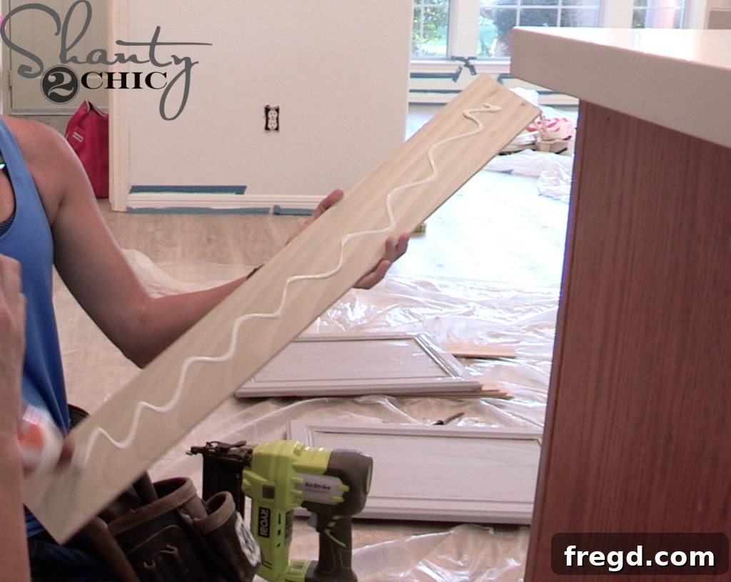 Craft boards being cut and wood glue applied for custom cabinet trim