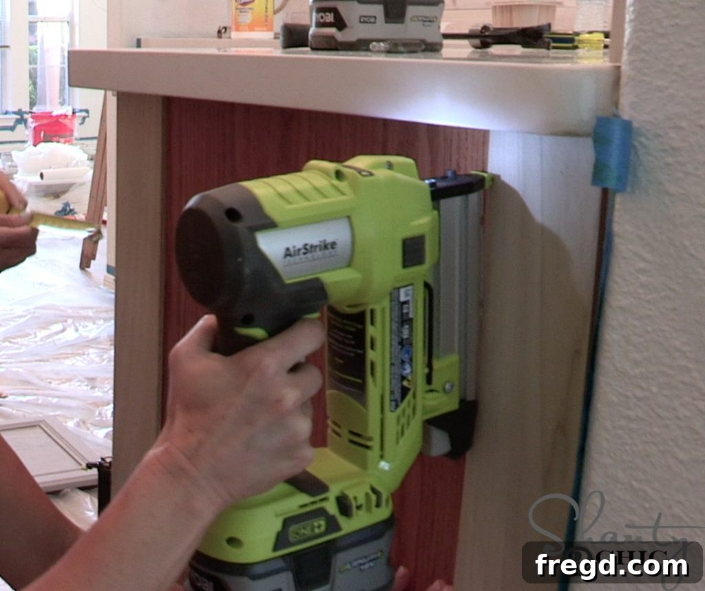 Pin nailer attaching craft boards to a kitchen cabinet end panel