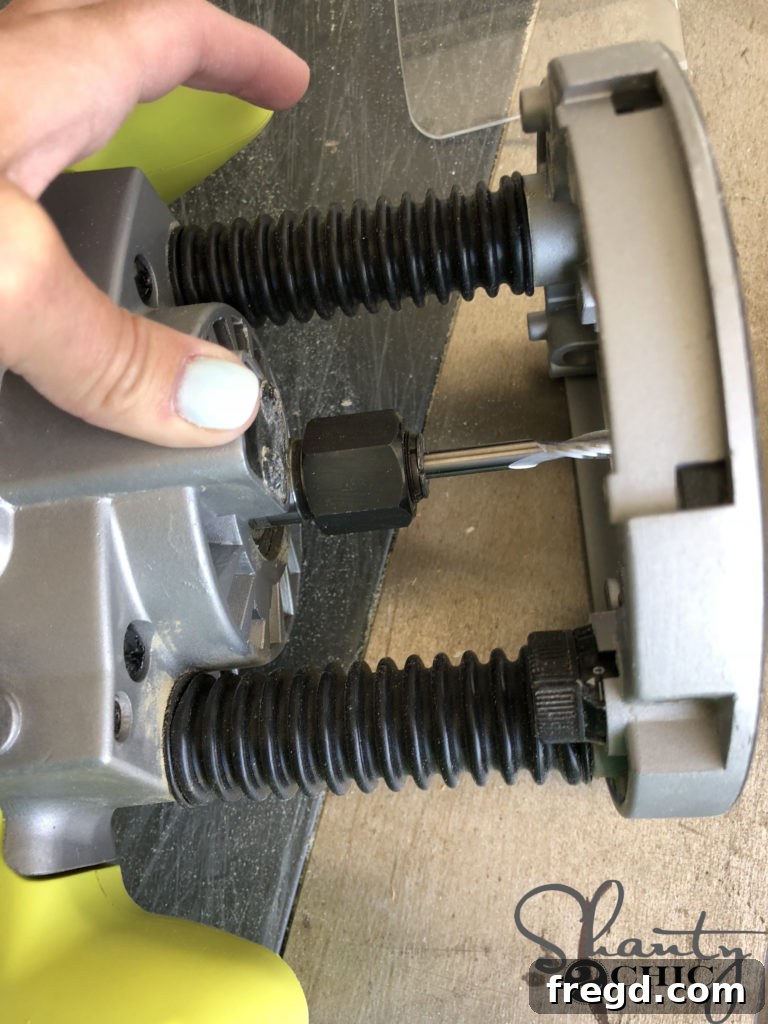 Demonstration of holding down the spindle lock to facilitate changing the router bit