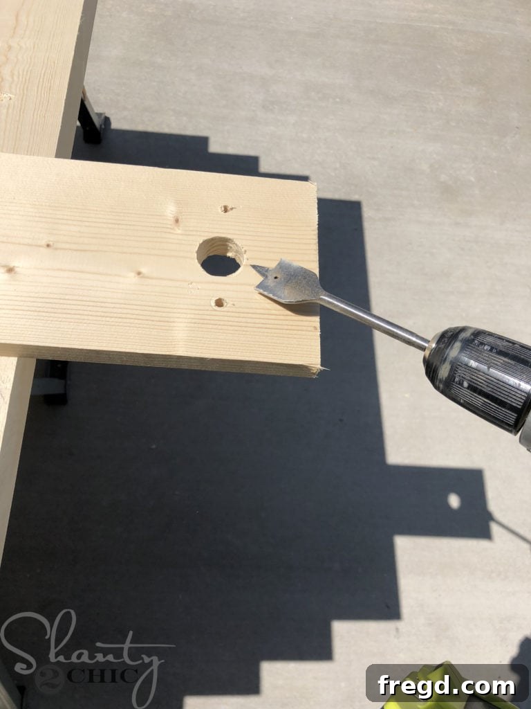 Drilling a 1-inch clearance hole using a paddle bit for the router bit's path through the jig