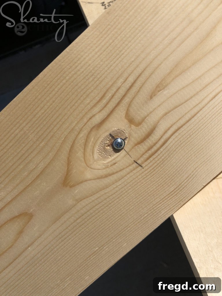 Drilling the single pivot screw into the marked spot on the jig board for central attachment