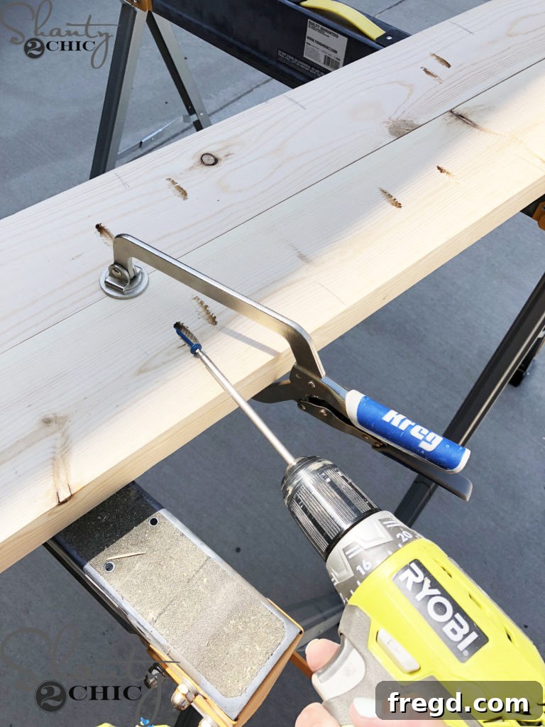 Detail of drilling precise 1.5-inch pocket holes into prepped lumber for tabletop assembly