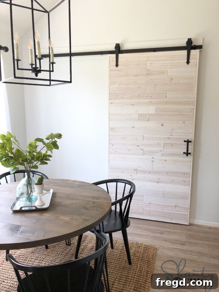Attaching the metal barn door track securely to the painted wooden header board above the doorway.