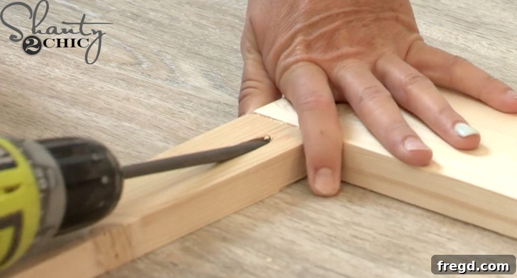 Drilling 3/4-inch pocket holes into the ends of 1x2 frame pieces using a Kreg Jig for strong, hidden joints.