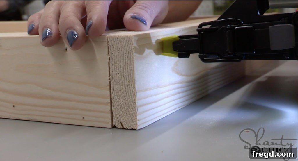 Attaching side decorative trim to the mirror frame with a brad nailer and wood glue