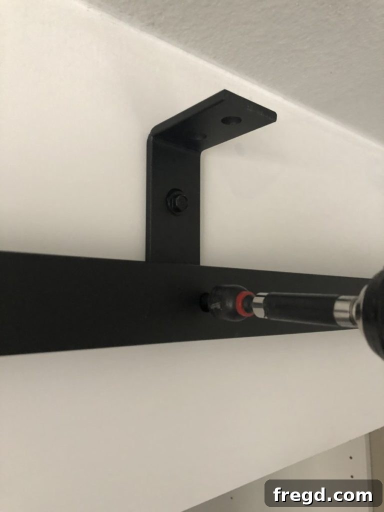 Securing the first metal track and spacers to the wall brackets