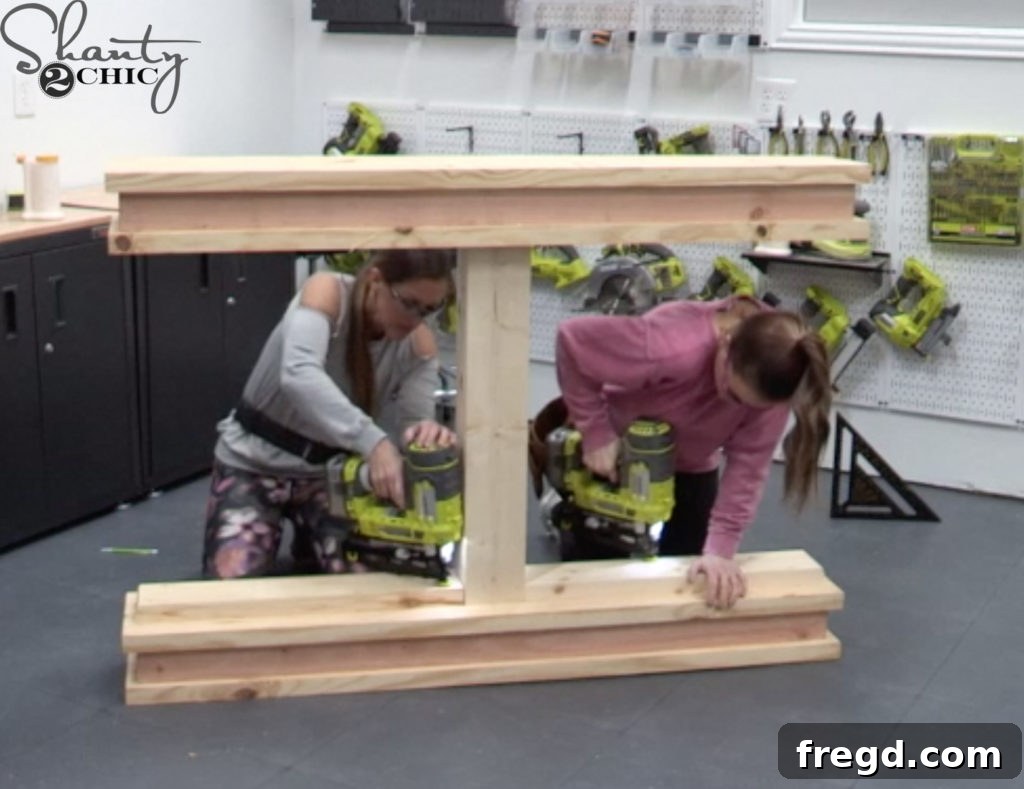 Horizontal trim pieces being carefully aligned and attached to the top and bottom bases of the console table, flush with the leg structure, to create the truss effect.