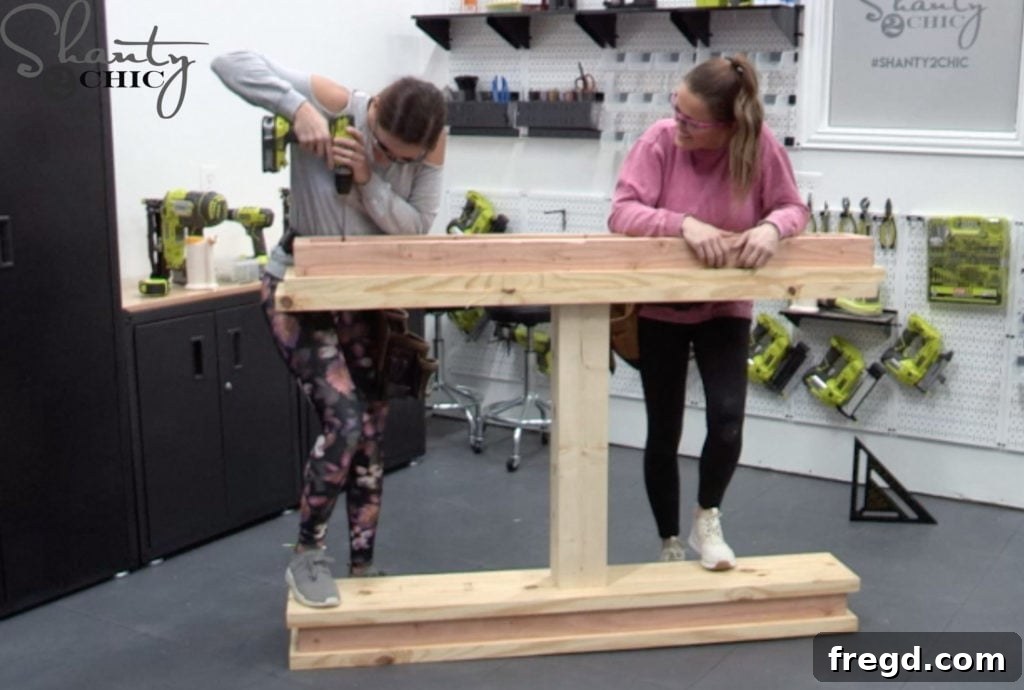 The second apron being centered and attached to the remaining, previously unattached plank using pocket hole screws and wood glue.