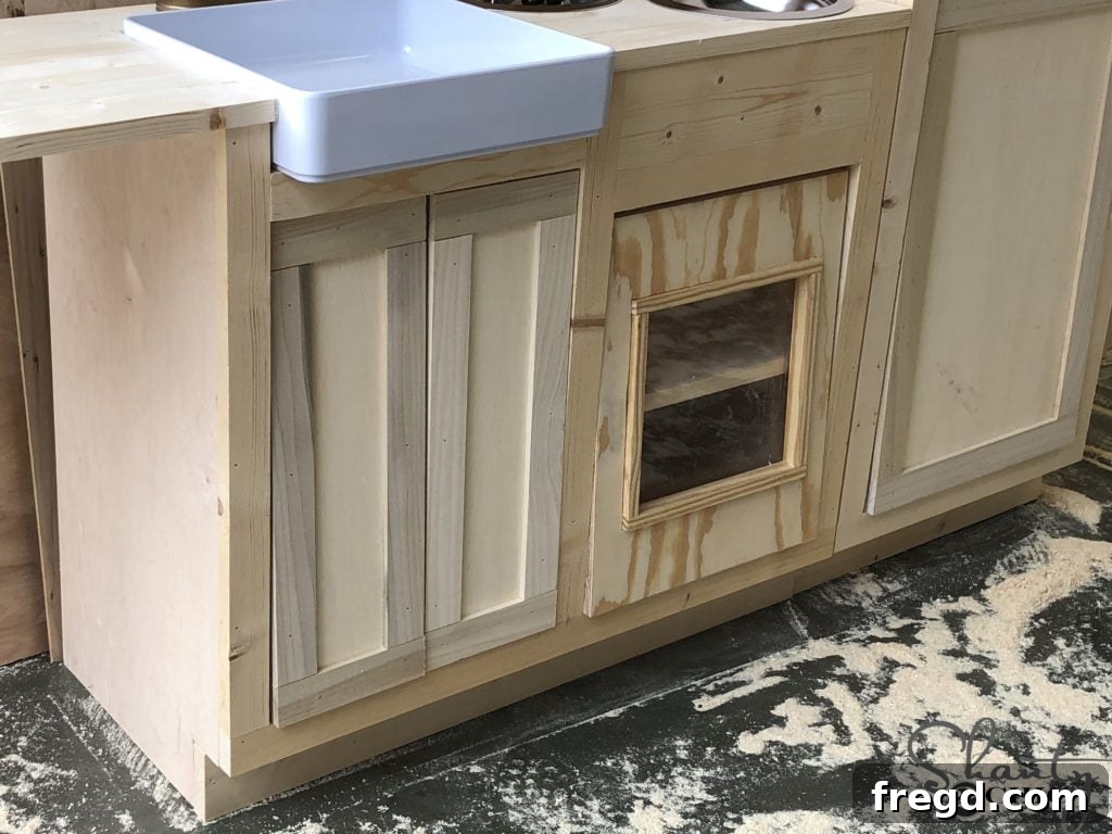Preparing to attach sink and oven doors with hinges