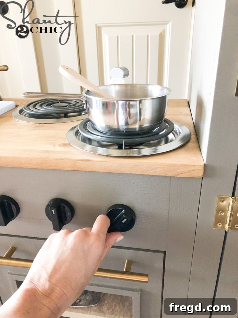 Child turning the functional oven knobs on her play kitchen