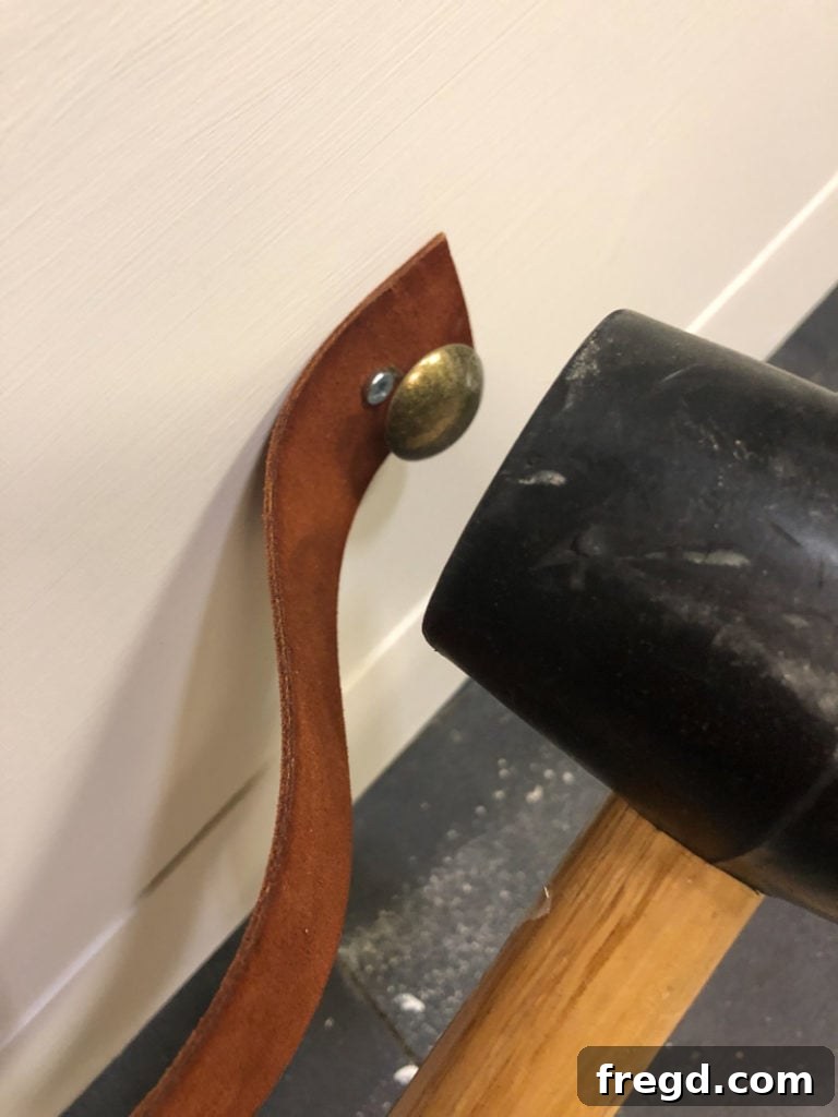 Applying decorative nail heads to cover screws on leather pulls