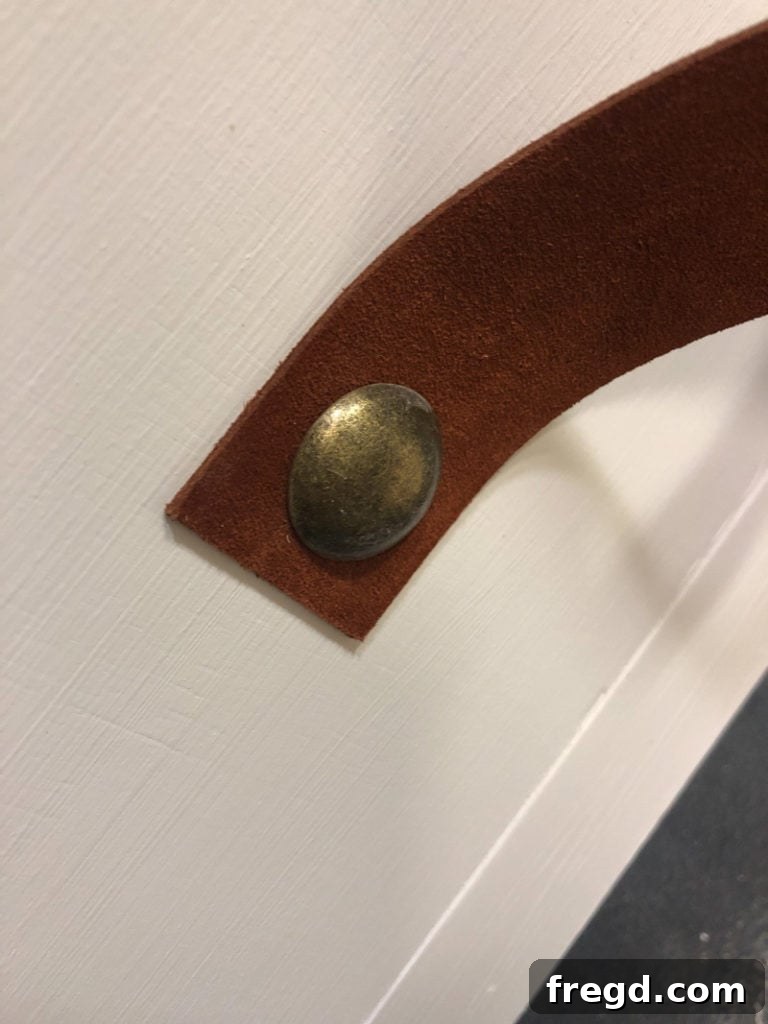 Finished leather pull with decorative nail head detail