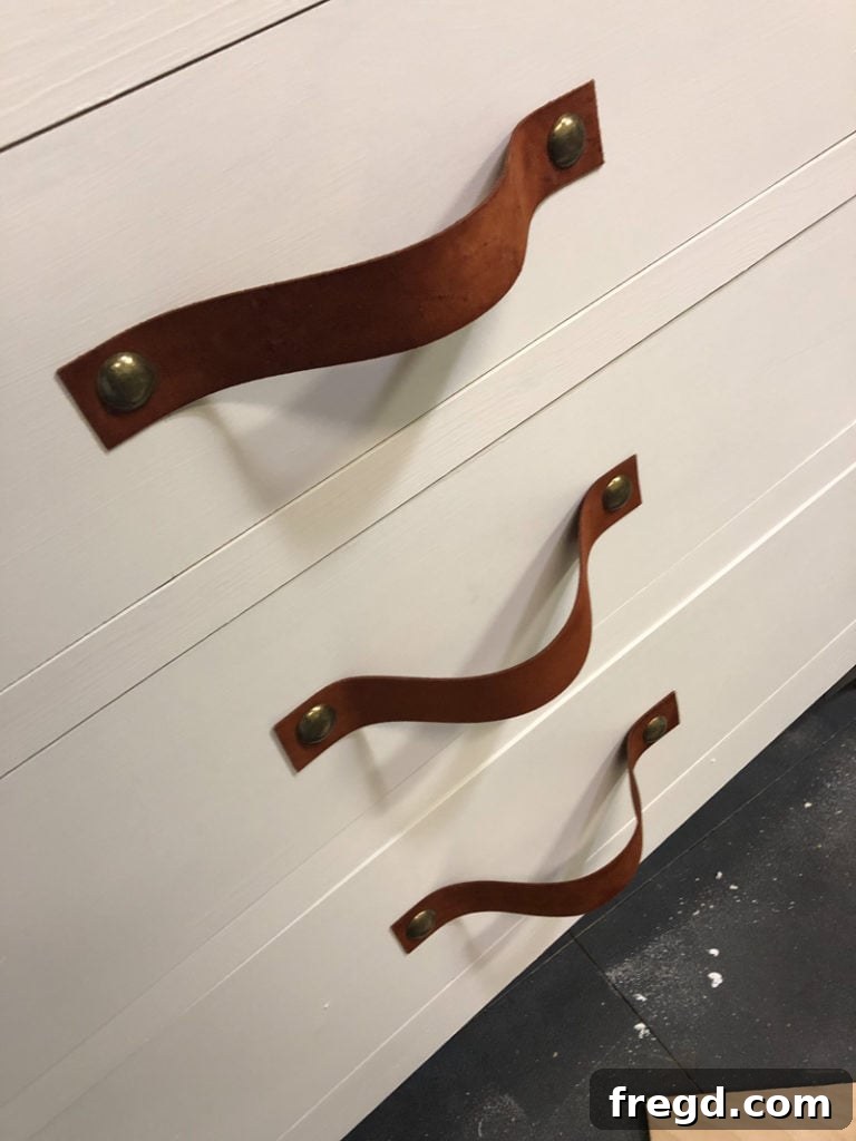 The three completed leather drawer pulls on the dresser