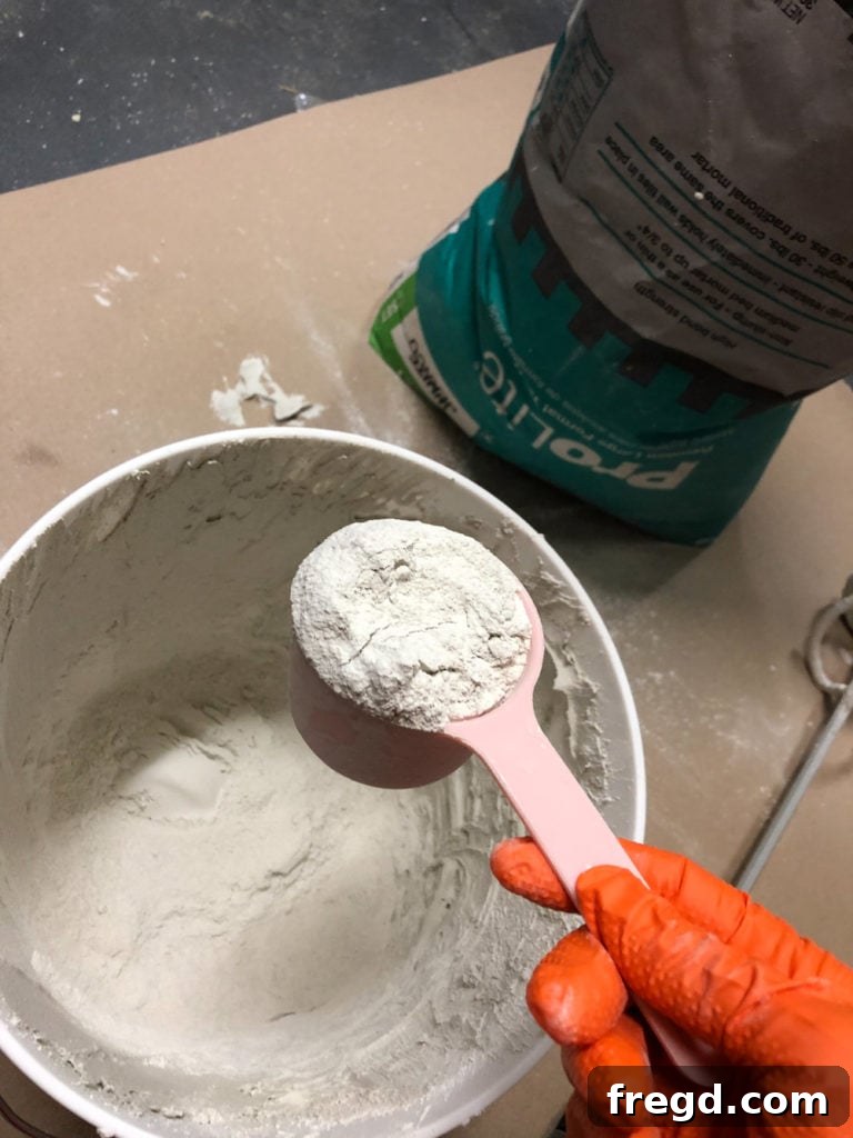 Adding powdered mortar mix to bucket