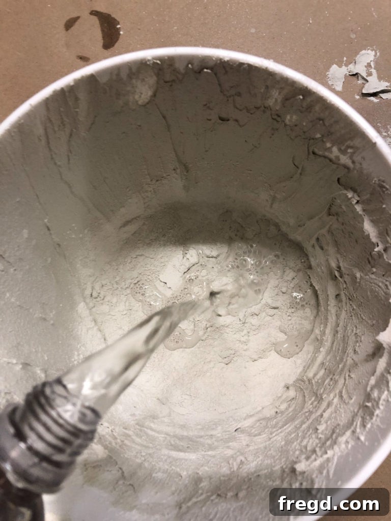 Pouring water into mortar mix for consistency